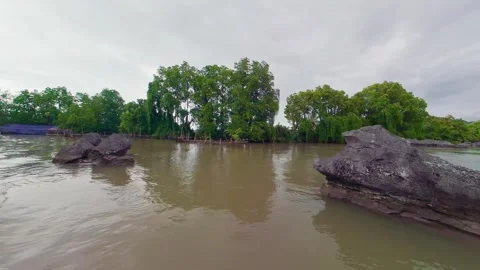 River Boat Passing Limestone Karst Rocks and Boulders in a Wide Tropical River Vidéo 336179367