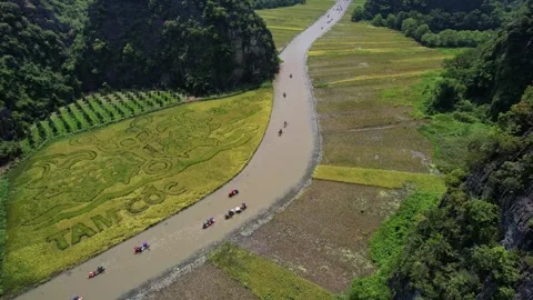 River with boats winding through mountainous terrain with rice fields and trees Stock Footage 274100532