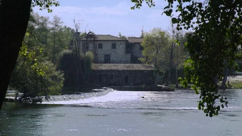 River with brick building and trees with cloudy sky, Portugal Stock-Footage 128928202