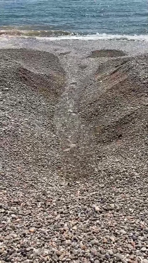 River bubbling through shingle into sea at Branscombe beach Stock Footage 153115900