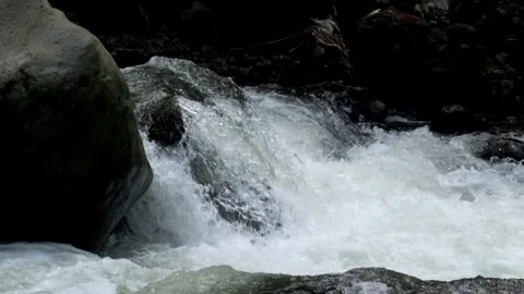 River cascade with clear, fast flowing water between large rocks Stock Footage 292663941