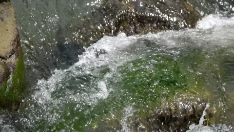 River cascade with clear, fast flowing water between large rocks Видео 292664206