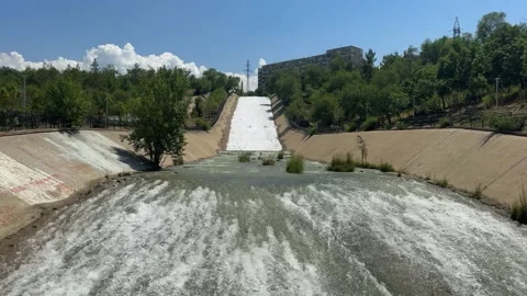 River in concrete channel, water flows. Big Almaty river near Sairan reservoir Stock Footage 325516978