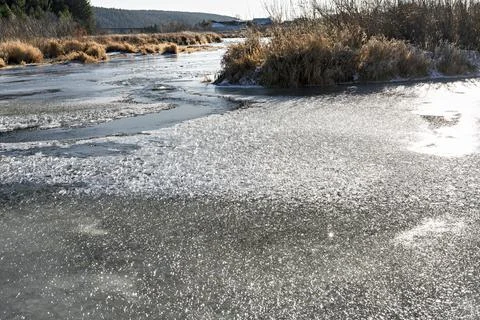 River covered with first ice and snow in late autumn or early winter forest Stock Photos