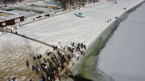 River is covered with ice, people enter the cold water, cross themselves Stock Footage 221989467
