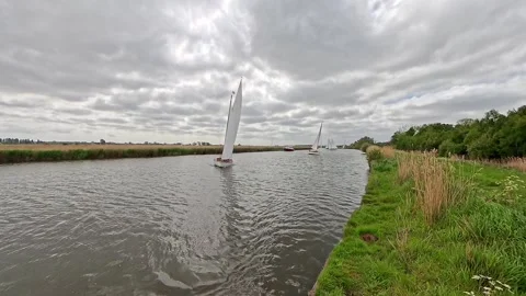 River cruiser tacking along the River Bure, Norfolk Broads Stock Footage 309830530