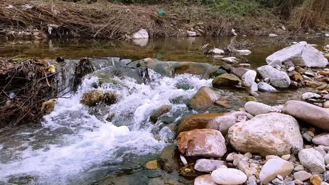 River of crystal clear water, passing through stones Stock Footage 128379955