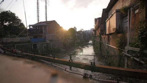 River cutting in two a slum on the sunset 스톡 동영상 76554566