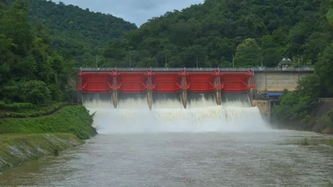 River downstream view of dam releasing floodwater with strong current and brown  Video stock 315568895