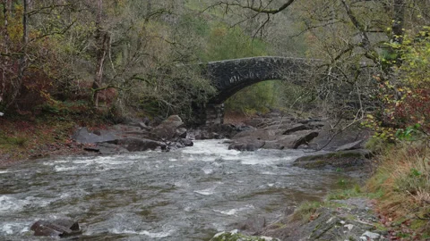 The river Elan flows under Penbont Bridge to the Garreg Ddu Reservoir. 4K tripod Stock Footage 222725428