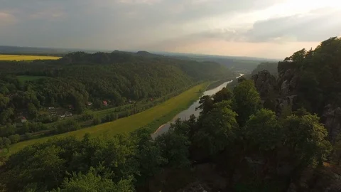 River Elbe next to Elbe sandstone mountains surrounded by trees on a sunny day Stock Footage 116190543