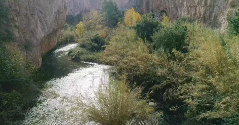 River encased between vertical walls of stone and reeds Stock Footage 124387628