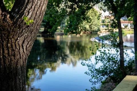 A river featuring a small stone dam with water cascading over the edge Stock Photos