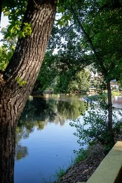 A river featuring a small stone dam with water cascading over the edge Stock Photos