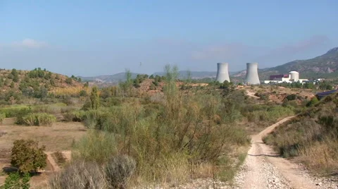 River floodplain with trees to dirt road to nuclear power plant. Pan right. Stock Footage 49963524