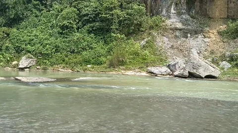 The river flow is clear and calm under the rock cliffs Stock Footage 195974532