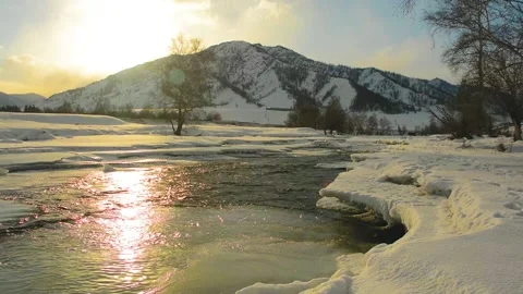 River flow. Glitter in the sunset. The cold winter in the mountains Stock Footage 130637122