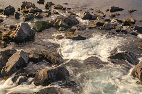 River flow in nature. Natural stream of river rock. Water of river flow in Stock Photos