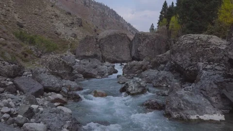 River flowing around massive boudlers in Himalayas in autumn Stock Footage 330440360