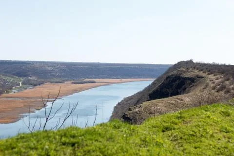 River flowing between hills and village in rural areas Stock Photos