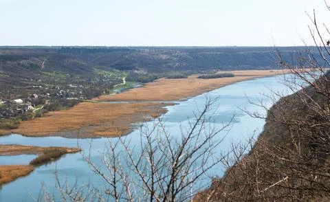 River flowing between hills and village in rural areas Stock Photos