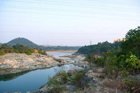 River flowing downhill between the mountain and mixing with a river Stock Photos