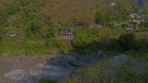 River flowing in front of small village Stock Footage 278350857