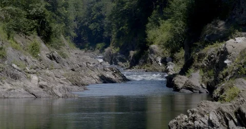 River flowing in a gorge through rocks and forest trees Stock Footage 121775316