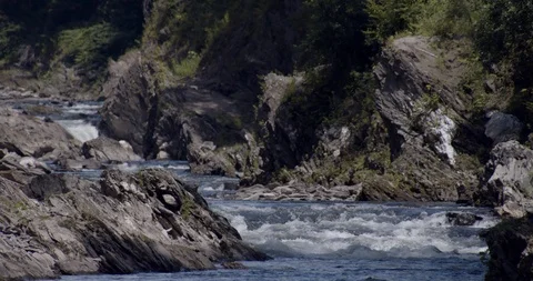 River flowing in a gorge through rocks and forest trees Stock Footage 122054809
