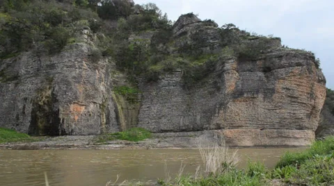 River flowing past cliff face Stock Footage 34411556