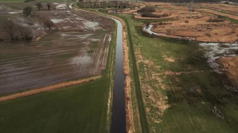 River flowing through cultivated fields near the city Stock Footage 293943392