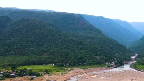 River Flowing Through Forested Mountain Valley with Settlement, Aerial View Stock Footage 341027604