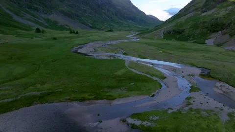 A river is flowing through a grassy valley Stock Footage 306492447