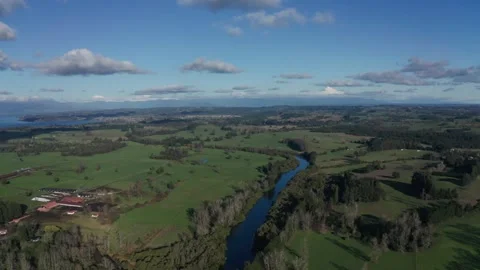 River Flowing Through Green Fields to a Lake Stock Footage 303603852