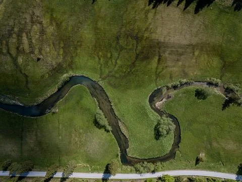 River flowing through green grass in the bavarian alps Stock Photos