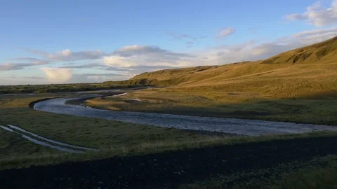 River flowing through green landscape during sunset Stock Footage 74908312