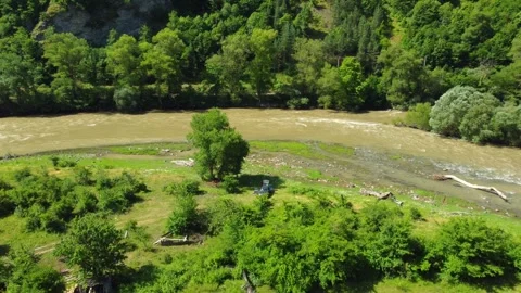 River flowing through green valley with mountains Video stock 285652609
