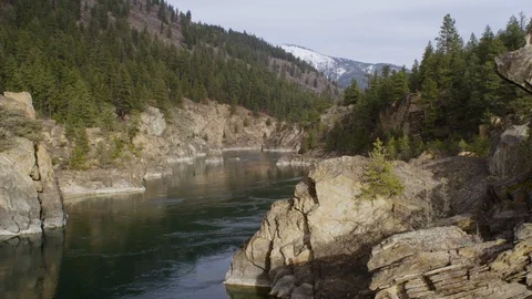 River flowing through rocky mountains with forest on a sunny day Stock Footage 116739611