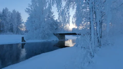 River flowing through snow and frost covered winter landscape Stock Footage 148400561