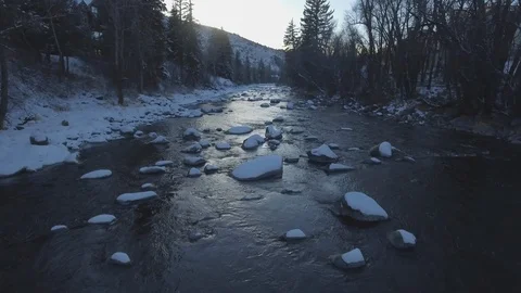 River flowing through snowy rocks during winter Stock Footage 105481899