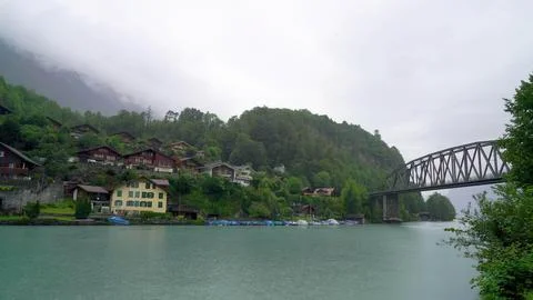 River flowing through a town surrounded by mountains and trees Stock Photos