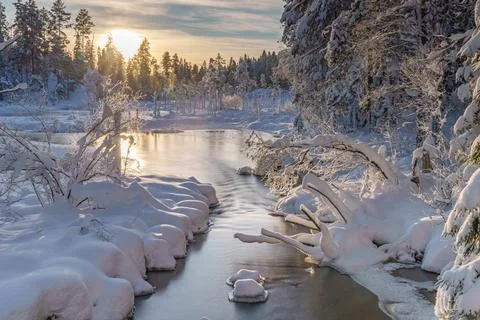 River flowing through the winter forest in Sweden Stock Photos