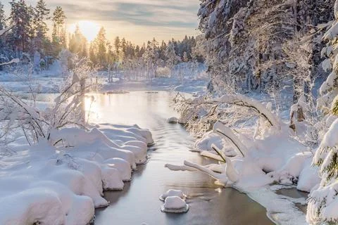 River flowing through the winter forest in Sweden Stock Photos