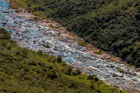 River Flowing Through Winter Vegetation Lined Valley Stock Photos