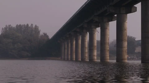 River flowing under the bridge on a sunny day in India Stock Footage 280358807