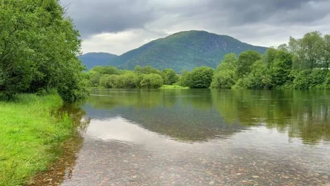 River flowing in a valley with mountains reflecting in Norway Stock Footage 315163213
