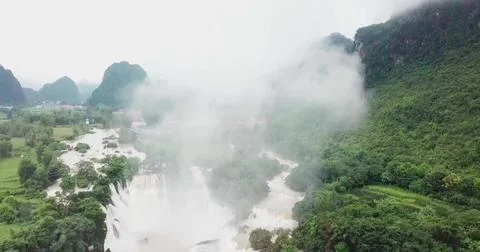 River Flowing into a Waterfall Through a Lush Mountain Forest Stock Photos