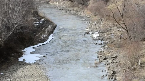 River flowing in winter between snow covered river banks Stock Footage 55433070