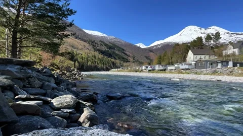 A river flows among the mountains and a campsite Stock Footage 337364968