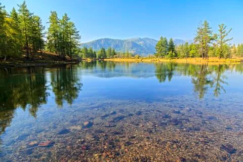 The river flows on a background of mountains and forests Stock Photos